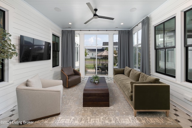 living room with wooden walls, ceiling fan, and crown molding