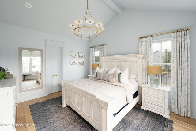 bedroom with hardwood / wood-style floors, vaulted ceiling with beams, and a notable chandelier