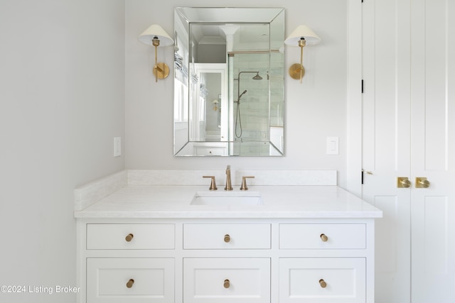 bathroom featuring a shower with shower door and vanity