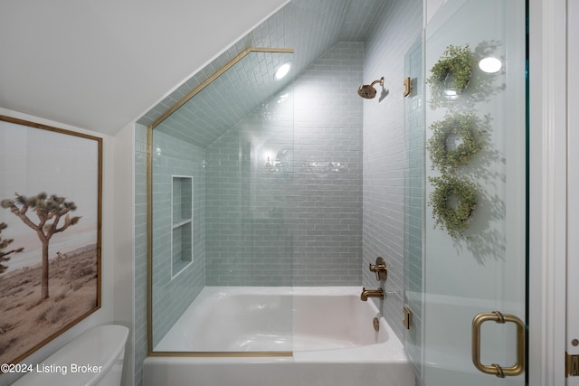 bathroom featuring bath / shower combo with glass door, toilet, and lofted ceiling