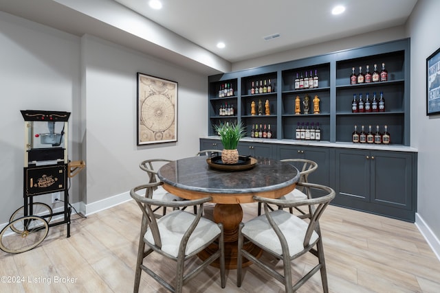 dining room featuring bar area and light wood-type flooring