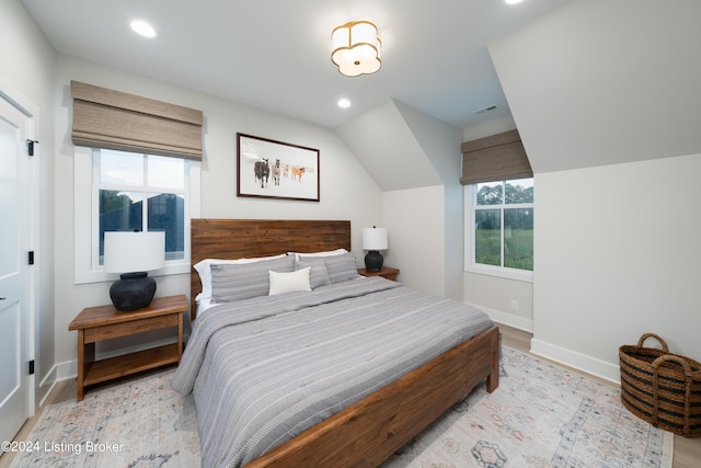 bedroom featuring light wood-type flooring and vaulted ceiling