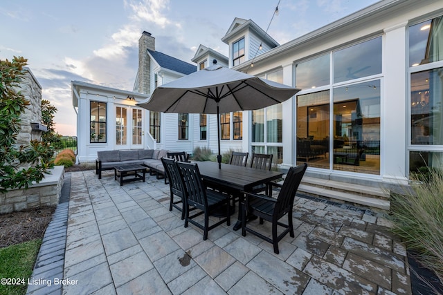 patio terrace at dusk featuring an outdoor living space