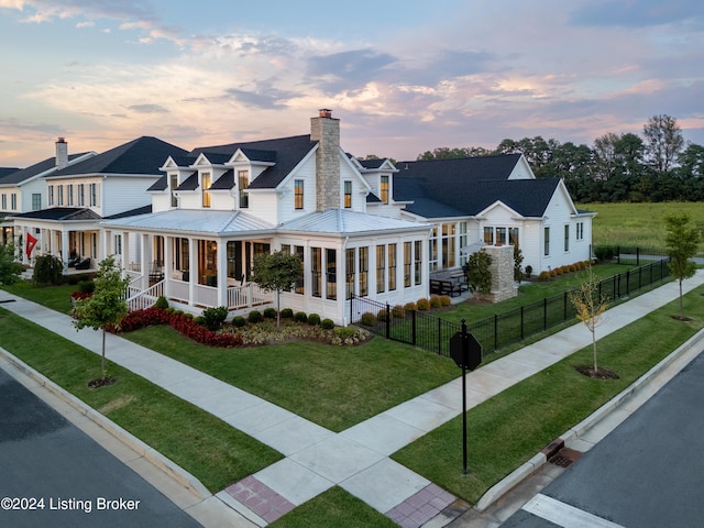 country-style home with a lawn and covered porch