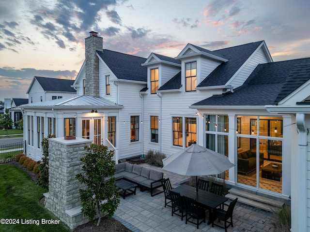 back house at dusk with a patio