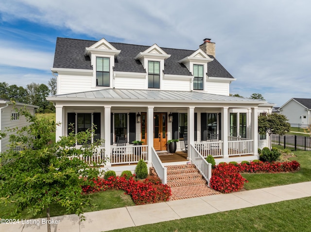 farmhouse inspired home with a front lawn and a porch