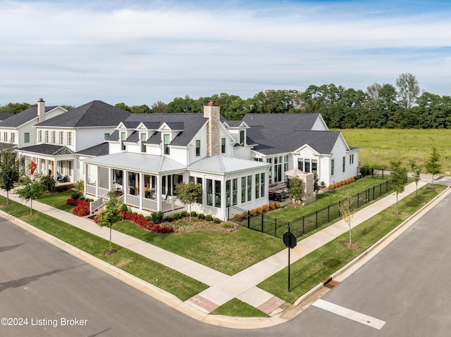 view of front of home featuring a front yard and a sunroom