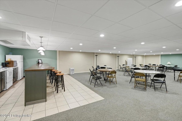 tiled dining room featuring a drop ceiling