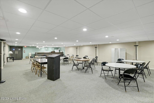 carpeted dining room featuring a drop ceiling