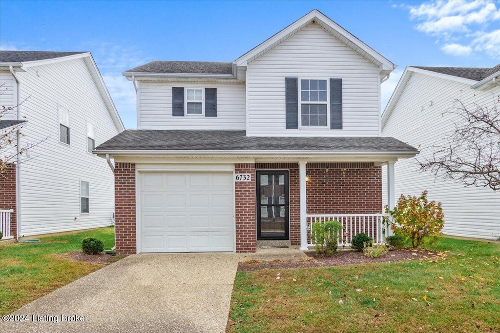 view of front of home featuring a front lawn, a garage, and covered porch