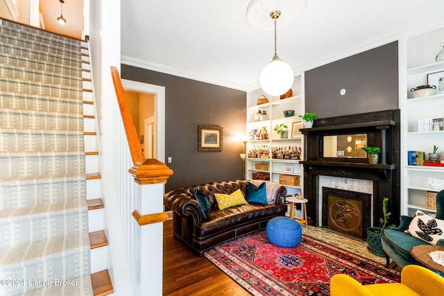 living room with dark hardwood / wood-style floors, ornamental molding, and a high end fireplace