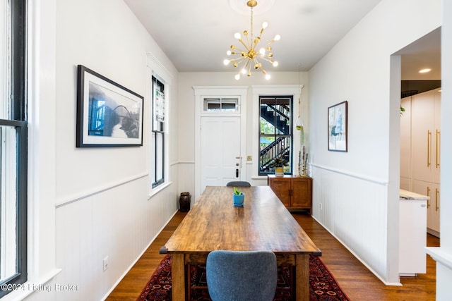 dining area featuring dark hardwood / wood-style floors and an inviting chandelier