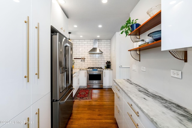 kitchen with dark hardwood / wood-style flooring, white cabinetry, wall chimney range hood, and high quality appliances