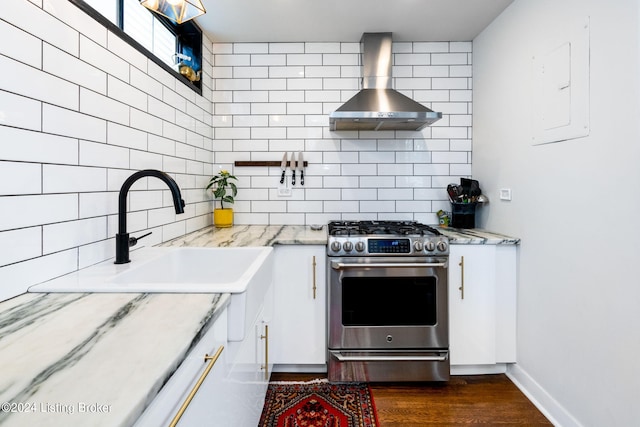 kitchen with white cabinets, light stone countertops, wall chimney exhaust hood, and high end range