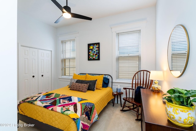 bedroom with light colored carpet, ceiling fan, and a closet