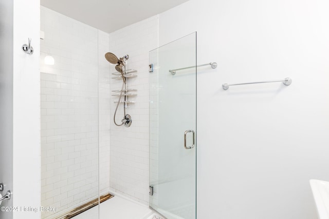 bathroom featuring a shower with door