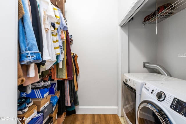 clothes washing area with washer and clothes dryer and light hardwood / wood-style floors