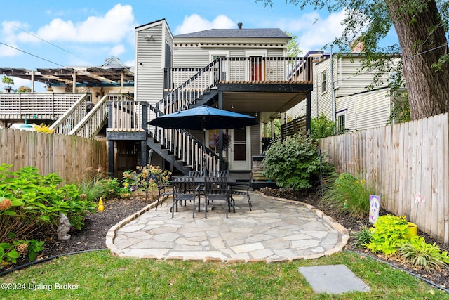 rear view of property with a wooden deck and a patio