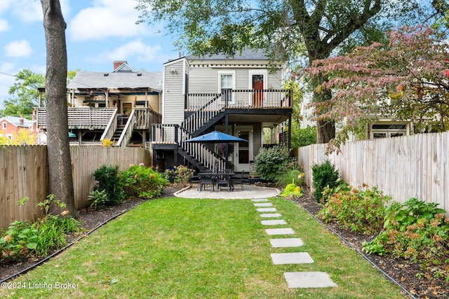 back of house featuring a deck, a lawn, and a patio