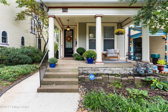 view of exterior entry featuring covered porch