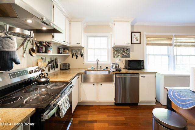 kitchen featuring stainless steel appliances, a wealth of natural light, wall chimney range hood, and white cabinetry