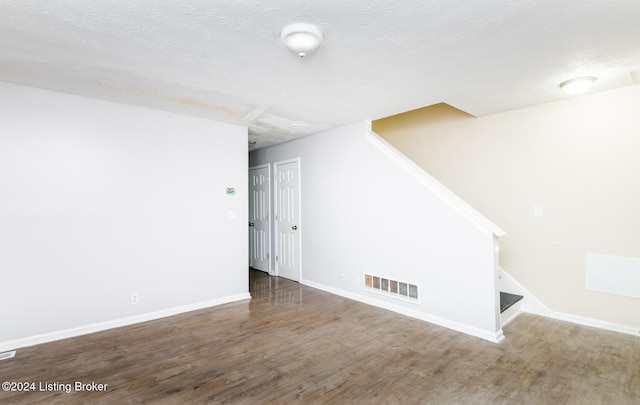 spare room with a textured ceiling and hardwood / wood-style flooring