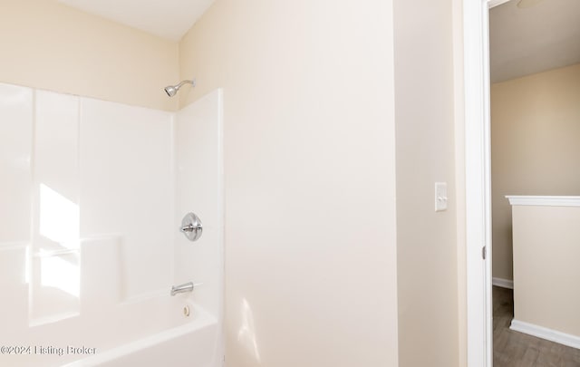 bathroom featuring washtub / shower combination and hardwood / wood-style flooring