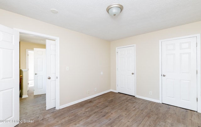 unfurnished bedroom featuring hardwood / wood-style floors and a textured ceiling