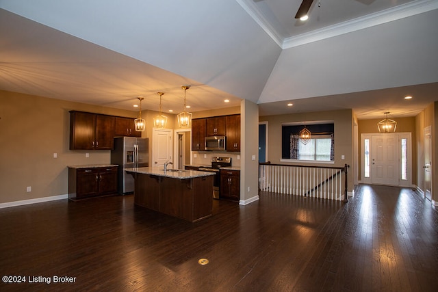 kitchen with hanging light fixtures, dark wood-type flooring, an island with sink, stainless steel appliances, and light stone counters