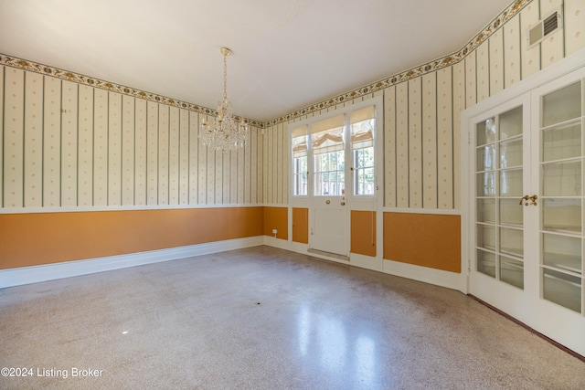 unfurnished room featuring a notable chandelier