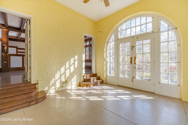 entryway with plenty of natural light, ceiling fan, concrete flooring, and french doors