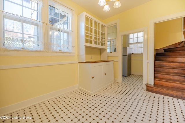 kitchen featuring stainless steel fridge, a healthy amount of sunlight, and a notable chandelier