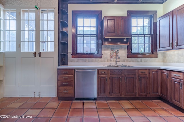 kitchen featuring stainless steel dishwasher, sink, a wealth of natural light, and tasteful backsplash