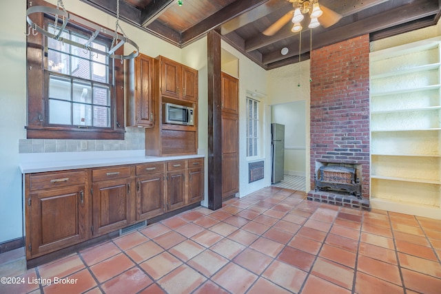 kitchen with a towering ceiling, wood ceiling, ceiling fan, beam ceiling, and light tile patterned floors