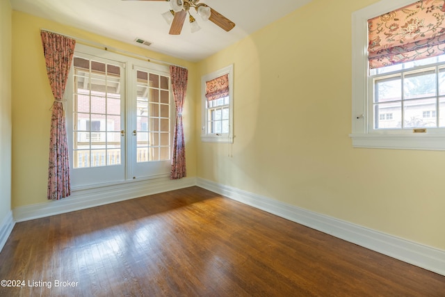 spare room featuring a wealth of natural light, dark hardwood / wood-style flooring, and ceiling fan