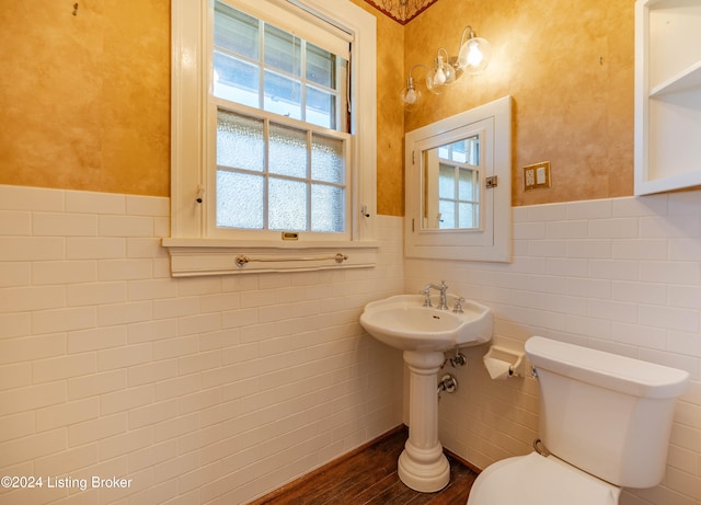 bathroom with hardwood / wood-style flooring, toilet, and tile walls