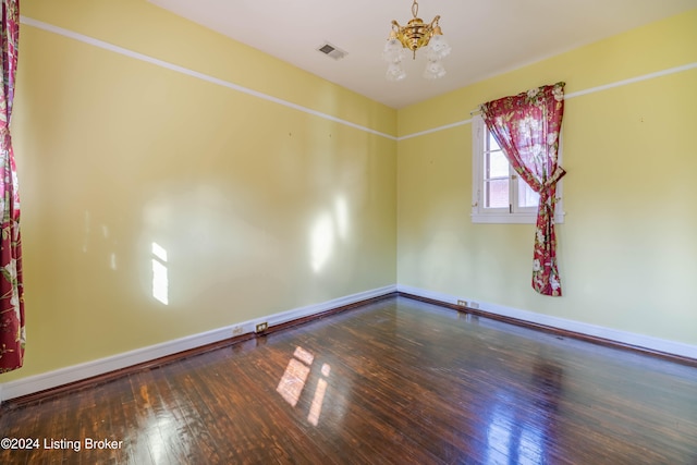 unfurnished room with a chandelier and hardwood / wood-style flooring