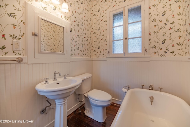 bathroom featuring a bath, sink, toilet, and hardwood / wood-style floors