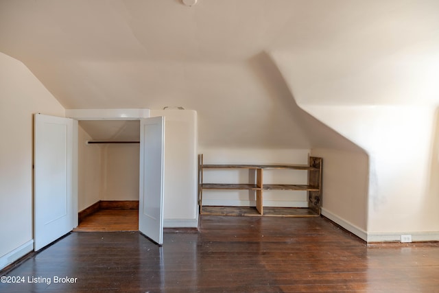 additional living space featuring dark hardwood / wood-style flooring and vaulted ceiling