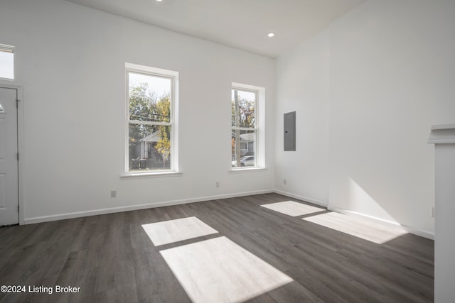 unfurnished living room featuring electric panel and dark hardwood / wood-style floors