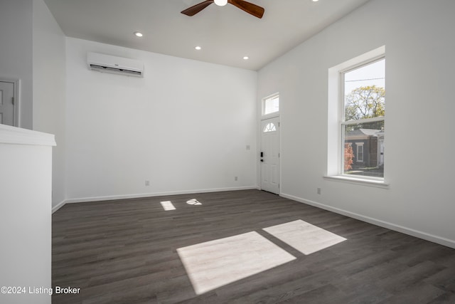 interior space featuring a wall unit AC, dark hardwood / wood-style flooring, and ceiling fan