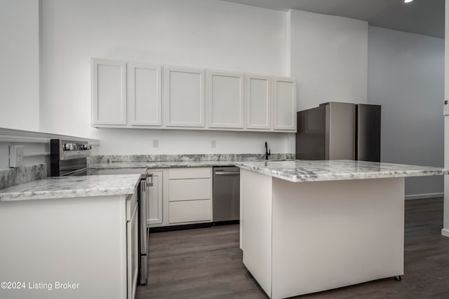 kitchen with white cabinetry, stainless steel appliances, a center island, and dark hardwood / wood-style flooring