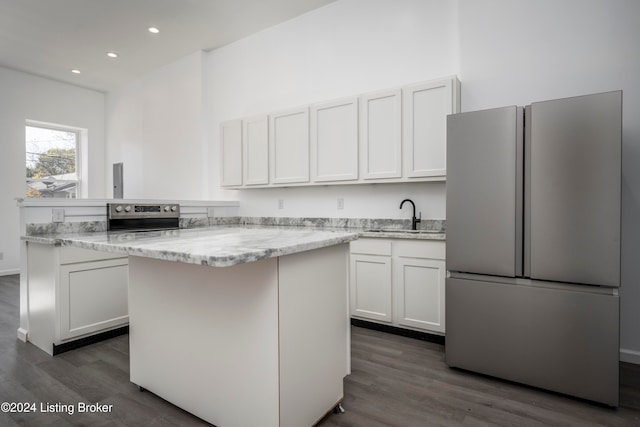 kitchen featuring white cabinets, appliances with stainless steel finishes, dark hardwood / wood-style floors, and light stone countertops