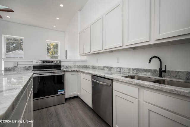 kitchen with light stone counters, stainless steel appliances, white cabinetry, dark hardwood / wood-style flooring, and sink