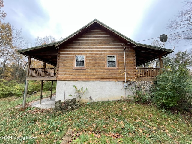 view of property exterior with a deck and a yard