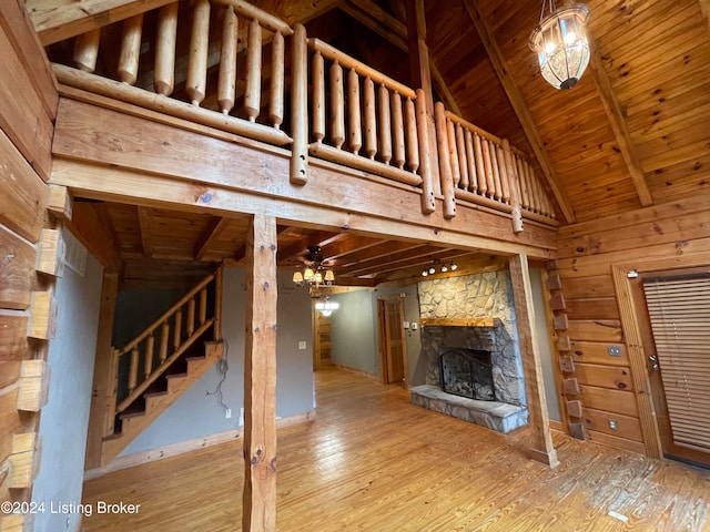 unfurnished living room featuring beam ceiling, wood ceiling, wood-type flooring, and a fireplace