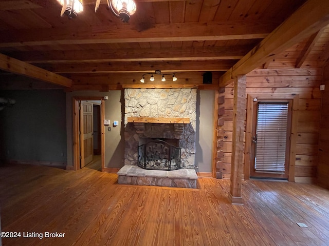 unfurnished living room featuring hardwood / wood-style floors, a fireplace, wood ceiling, and beam ceiling