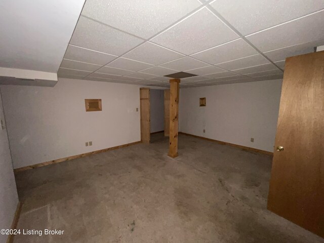 basement with a drop ceiling and carpet