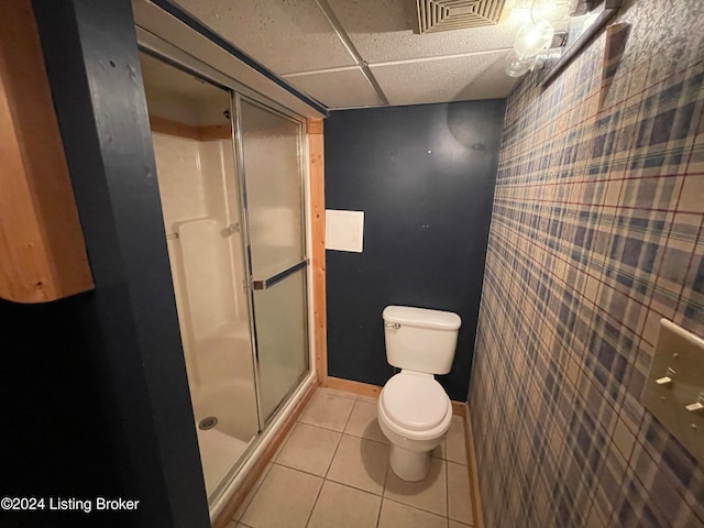 bathroom featuring a shower with shower door, tile patterned flooring, and toilet