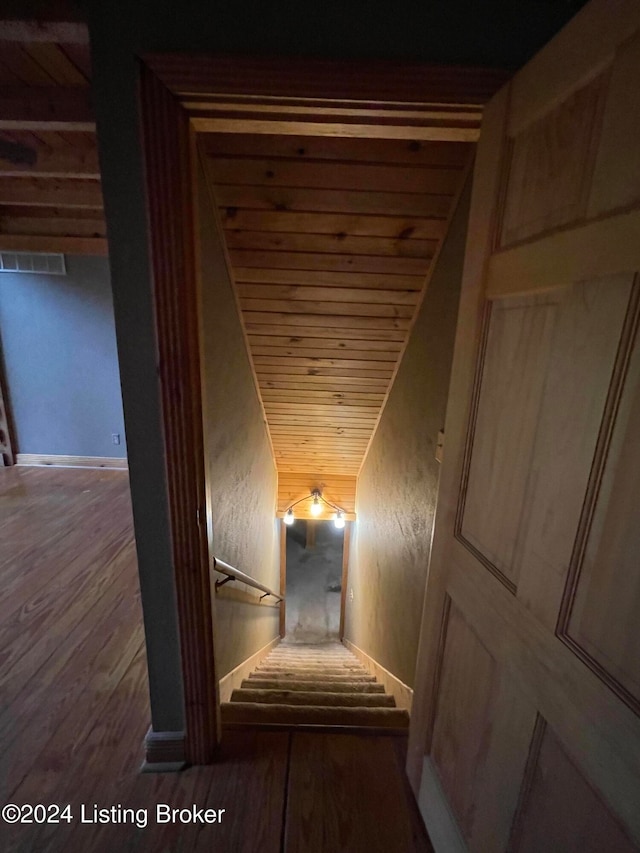 stairs with hardwood / wood-style flooring and wooden ceiling